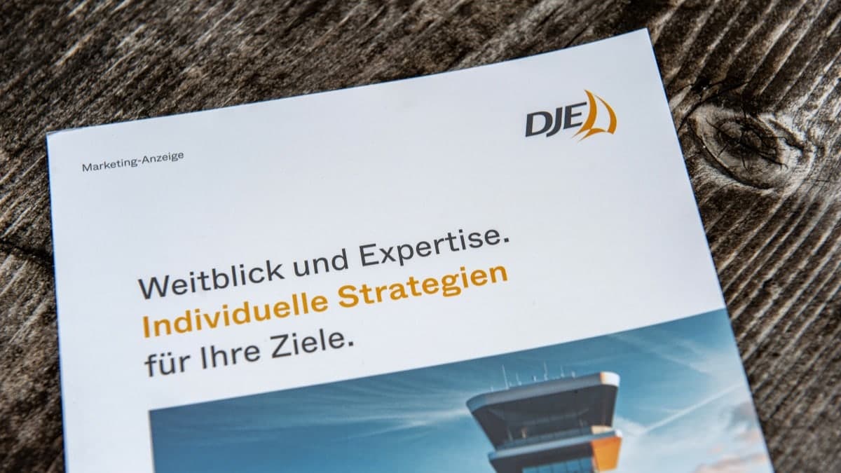 Informationsmaterial von DJE Kapital auf einem Holztisch